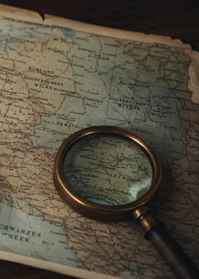 An old map of Eastern Europe under a brass magnifying glass